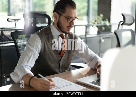 Modern Office Businessman Working on Computer. Portrait of Successful Middle-aged IT Software Engineer Working on a Laptop at his Desk Stock Photo
