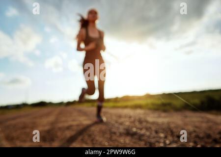 When your legs get tired, run with your heart. a fit young woman out for a run on a beautiful day. Stock Photo