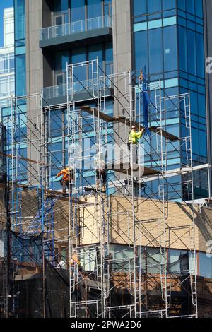 Workers constructing repointing scaffolding on an office building on 34th St. in Midtown Manhattan, 2023, New York City, USA Stock Photo