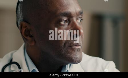 Medical portrait mature doctor general practitioner cardiologist therapist physician looking at camera smiling african ethnic medic scientist in white Stock Photo
