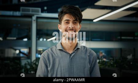 Portrait happy indian young man professional businessman entrepreneur agent manager stand in office confident smiling male looking at camera arabian Stock Photo