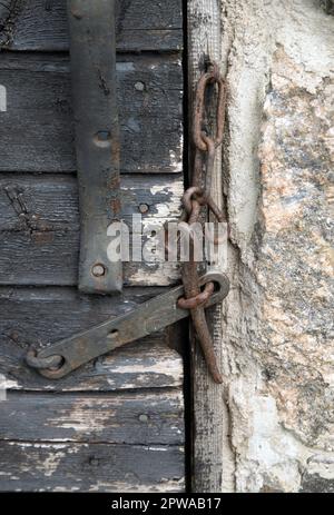 Old hook on closed door Stock Photo