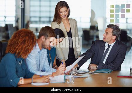 She turned her cants into cans. a group of businesspeople having a meeting in the boardroom. Stock Photo