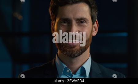 Close up headshot Caucasian adult man professional businessman manager CEO agent stand in evening night office smiling 40s millennial happy male Stock Photo