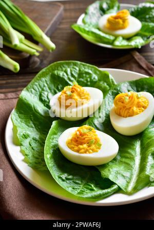 Deviled eggs with paprika, mustard and mayonnaise on plate over wooden background. Close up view Stock Photo