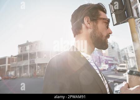 Metro man on the move. a stylish young man having a coffee on the go in the city. Stock Photo