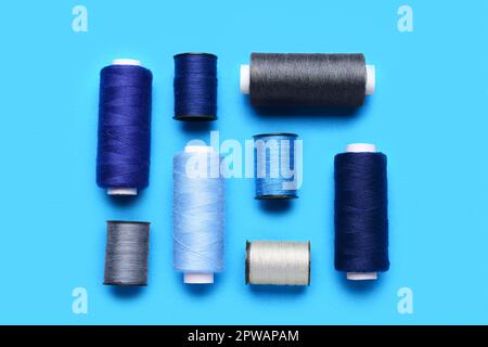 Composition with different thread spools on color background Stock Photo
