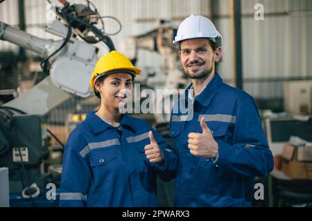 Portrait engineer technician team happy smile thumbs up. Engineers worker enjoy working together in heavy industry. Stock Photo