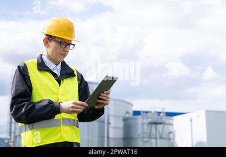 Engineer with digital tablet on a background of gas tanks. High quality photo Stock Photo