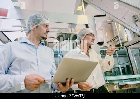 Winemaker professional standard officer work chek hygiene quality of beverage production in line drink factory Stock Photo