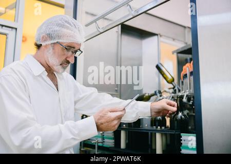 Winemaker professional standard officer work chek hygiene quality of beverage production in line drink factory Stock Photo