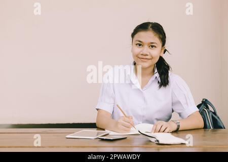 portrait southeast asian young teen student sitting education learning in school uniform with copy space. Stock Photo