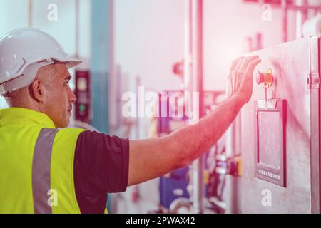 factory engineer staff pressing Emergency Stop Switch machine  malfunctioning for safety Stock Photo