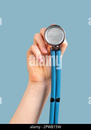 Hand holding stethoscope on blue background, to you me. Stock Photo