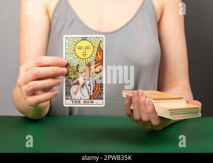 Lodz Poland April 15 2023 The Sun arcana, hand holding showing tarot card during divination. Stock Photo