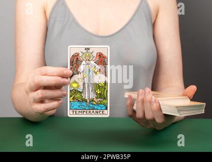 Lodz Poland April 15 2023 Temperance arcana, hand holding showing tarot card during divination. Stock Photo