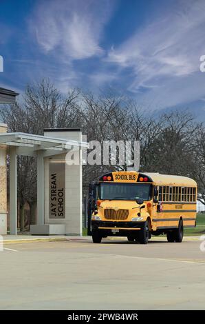 Carol Stream, Illinois, USA. A school bus waiting for passengers by an entrance at a suburban Chicago public middle school. Stock Photo