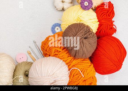 A set of colorful clew of thread for knitting and special craft tools. Handmade, hobby, crochet concept. Props and stuff on light stone concrete backg Stock Photo