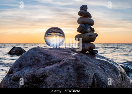 Stone pyramids and glass sphere on the dreamy Baltic Sea sand beach on Rügen for the spectacular sunset Stock Photo