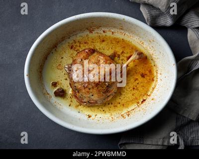 freshly roasted duck confit, duck leg in oven pan, top view Stock Photo