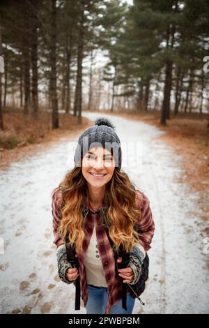 Lets go play in the snow. Portrait of a young woman hiking in the wilderness during winter. Stock Photo