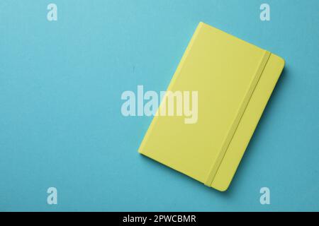 New stylish planner with hard cover on light blue background, top view. Space for text Stock Photo