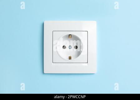 Power socket on light blue wall. Electrical supply Stock Photo