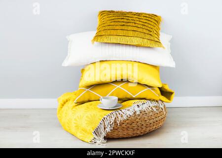 Pink and white pillows and cup of coffee on the wall background. Close up Stock Photo