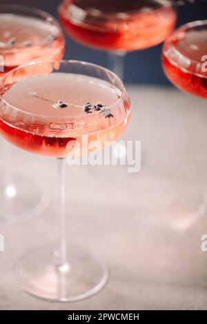 Set of glass goblets with champagne and flowers placed on table in restaurant Stock Photo