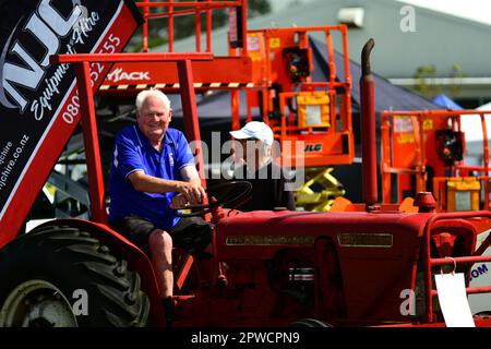 Auckland, New Zealand - Mar 2023. An elderly farmer riding an antique rusty tractor Stock Photo