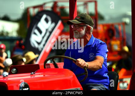 Auckland, New Zealand - Mar 2023. An elderly farmer riding an antique rusty tractor Stock Photo