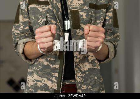 Handcuffed soldier, arrested male army officer in dark prison cell Stock Photo