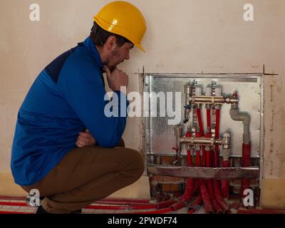 Underfloor heating installation. Water floor heating system interior. Plumbing pipes in apartment during renovation. Underfloor heating manifold. The Stock Photo