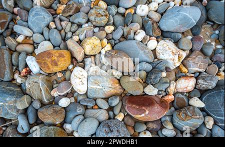 amazing to see on the beach is full of round rocks instead of sand.  round rocks have beautiful color and various size.  rocks beach at the lighthouse Stock Photo