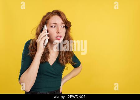 Worried redheaded woman talking to the mobile Stock Photo