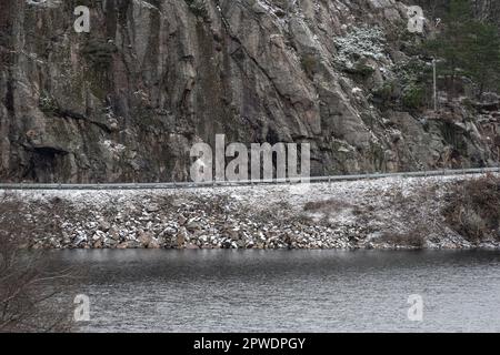 Narrow road carved out of a steep cliffside Stock Photo