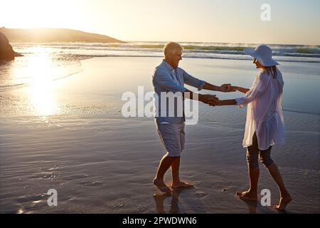 Were only growing younger. a mature couple spending the day at the beach. Stock Photo