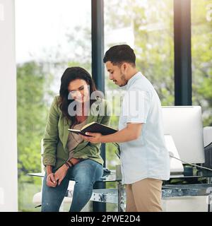 Heres what we discussed before. two creative colleagues sharing ideas in their office. Stock Photo