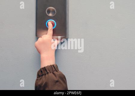 A small child presses the elevator call button. Baby reaches for the elevator button in a residential building. Kid aged about two years (one year ten Stock Photo