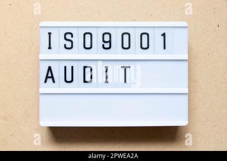 Lightbox with word ISO 9001 audit on wood background Stock Photo