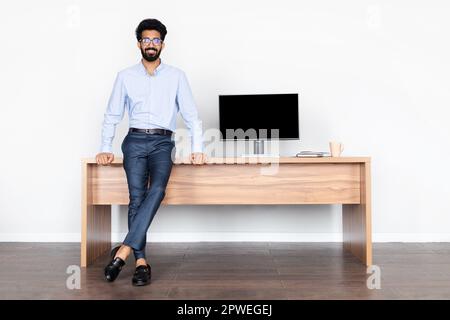 Cheerful handsome middle eastern man posing at office Stock Photo