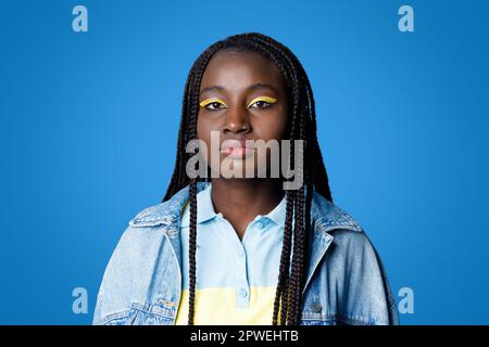 Cool stylish young black woman posing on blue Stock Photo