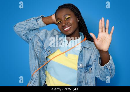 Cool pretty young black lady showing her palm and smiling Stock Photo