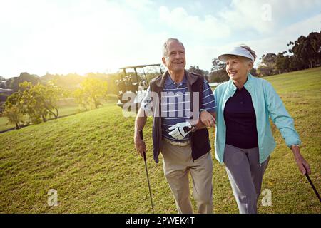 Couples golf. a smiling senior couple enjoying a day on the golf course. Stock Photo