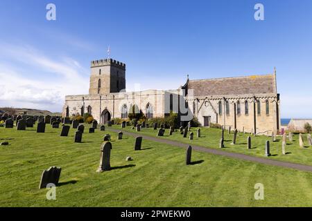 St Aidans Church Bamburgh Northumberland UK; exterior view on a sunny spring day with blue sky. Tomb of Grace Darling can be seen far left. Stock Photo