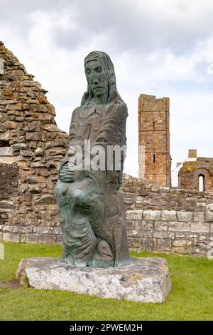 The modern-day statue of St Cuthbert in the grounds of Lindisfarne Priory, Lindisfarne, Holy Island Northumberland UK Stock Photo