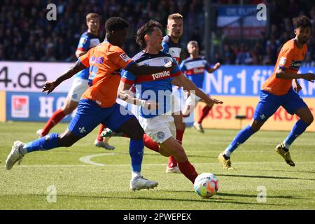 30 April 2023, Schleswig-Holstein, Kiel: Soccer: 2nd Bundesliga, Holstein Kiel - Darmstadt 98, Matchday 30, Holstein Stadium. Darmstadt's Braydon Manu (left) and Kiel's Fabian Reese race for the ball. Photo: Gregor Fischer/dpa - IMPORTANT NOTE: In accordance with the requirements of the DFL Deutsche Fußball Liga and the DFB Deutscher Fußball-Bund, it is prohibited to use or have used photographs taken in the stadium and/or of the match in the form of sequence pictures and/or video-like photo series. Stock Photo