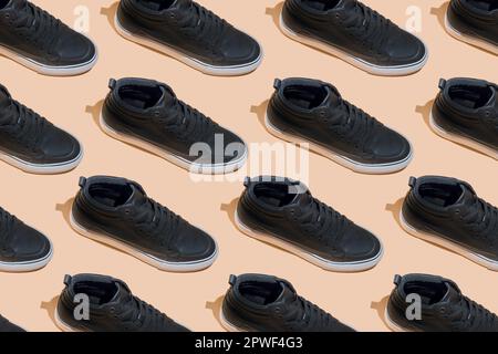 Shoe pattern. Black shoes on a beige pastel background top view with shadow. Accessories concept. New leather shoes. Classic sport style. Fashion shoe. Flat minimalistic store advertising. Footwear. Stock Photo
