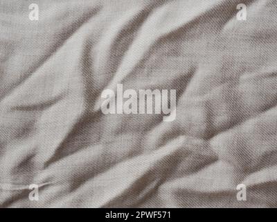 Minimalistic background for design. Wrinkle beige linen texture. Detailed closeup. Rustic crumpled vintage cotton fabric. Comfortable style cloth Stock Photo