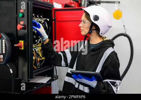 Young technician checking and repairing part of automatic machine Stock Photo